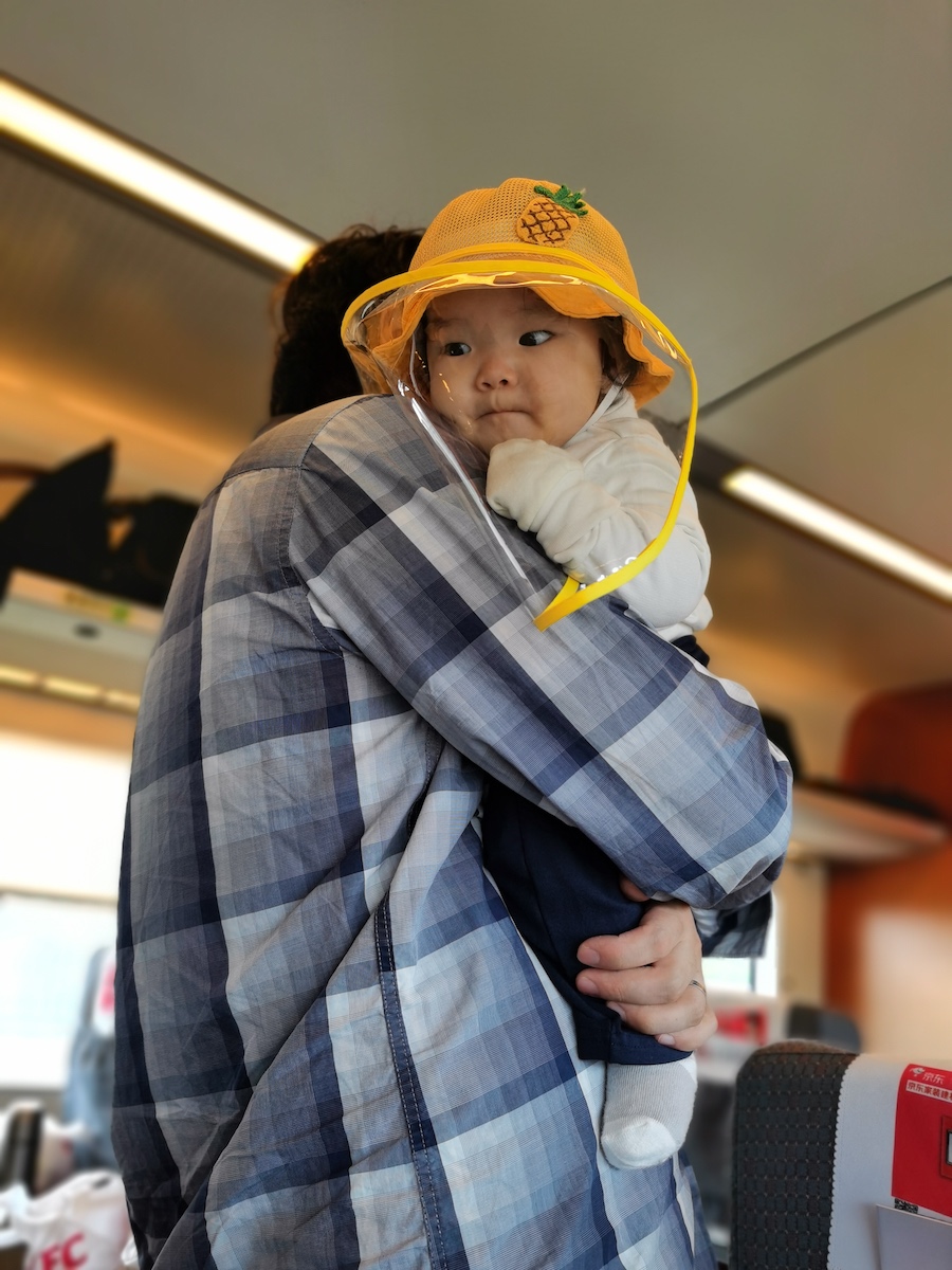 A photo of Coaca Bean riding a train with his parents.